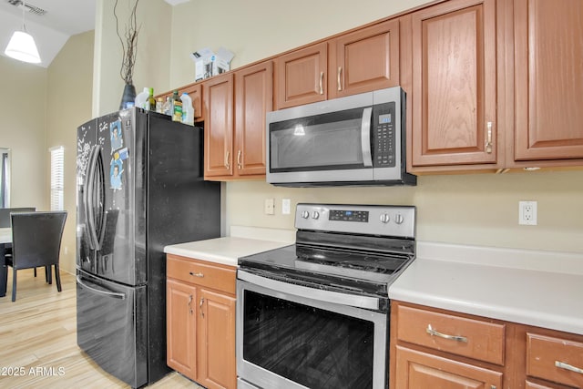 kitchen with visible vents, light countertops, hanging light fixtures, light wood-style flooring, and appliances with stainless steel finishes