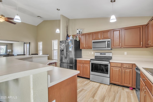 kitchen with stainless steel appliances, visible vents, light wood-style floors, vaulted ceiling, and pendant lighting