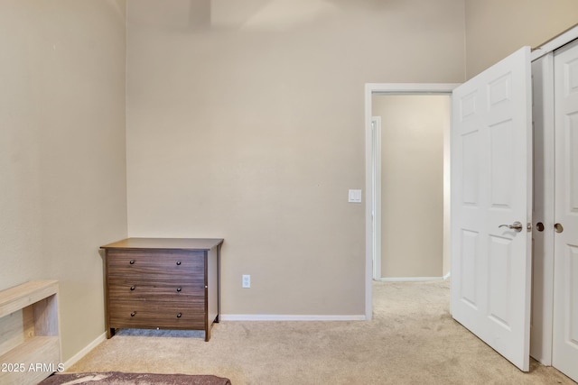 unfurnished bedroom featuring light carpet and baseboards