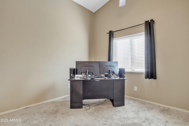 carpeted office with vaulted ceiling and baseboards