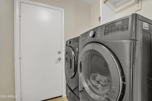 clothes washing area featuring laundry area and washing machine and clothes dryer