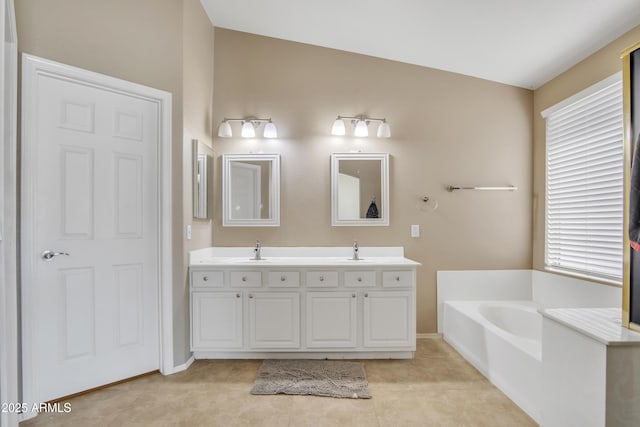 bathroom featuring tile patterned floors, double vanity, a sink, and a bath