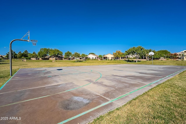 view of basketball court with community basketball court and a lawn