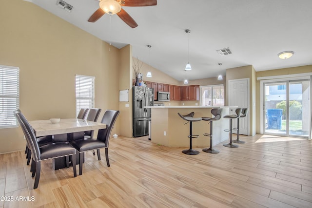 dining room with light wood-type flooring, plenty of natural light, and visible vents