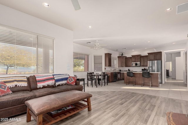 living room featuring ceiling fan and light wood-type flooring