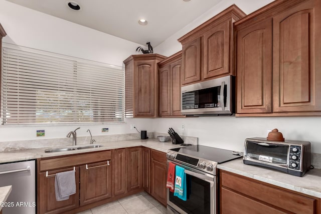 kitchen featuring light tile patterned floors, stainless steel appliances, and sink