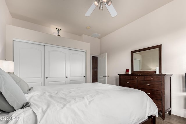 bedroom with a closet, hardwood / wood-style flooring, and ceiling fan