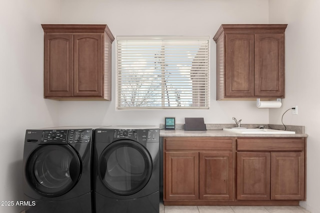 washroom featuring cabinets, sink, light tile patterned floors, and washer and dryer