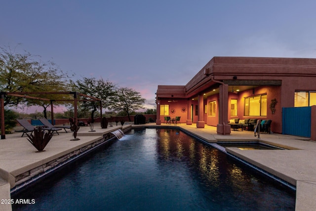 pool at dusk with a patio area