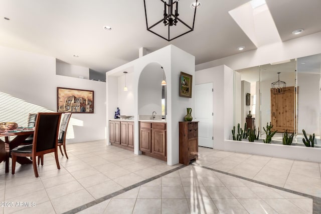 tiled dining space featuring sink and a chandelier