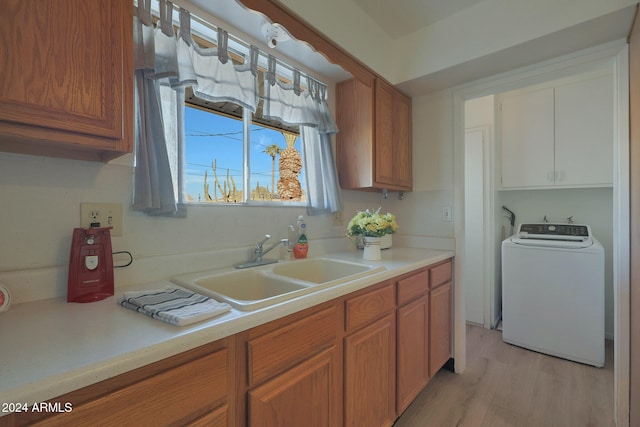 kitchen with washer / dryer, light wood-type flooring, and sink