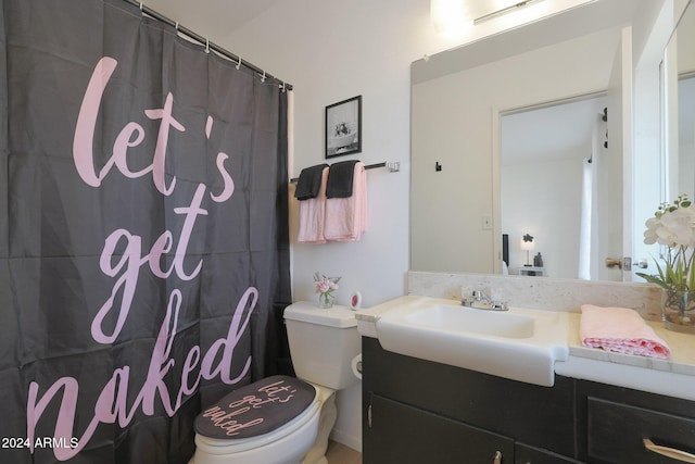 bathroom with walk in shower, vanity, and toilet