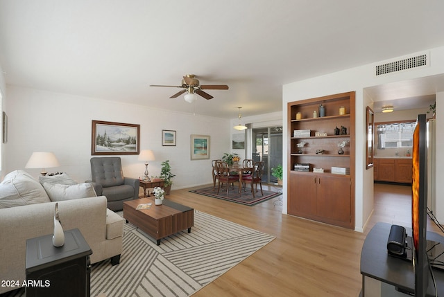 living room with ceiling fan and light hardwood / wood-style flooring