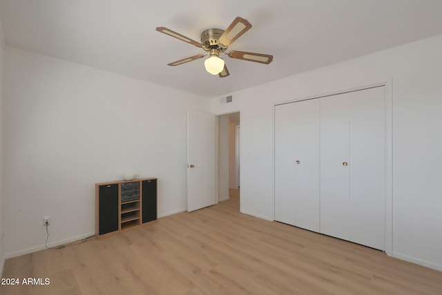 unfurnished bedroom with light wood-type flooring, a closet, and ceiling fan