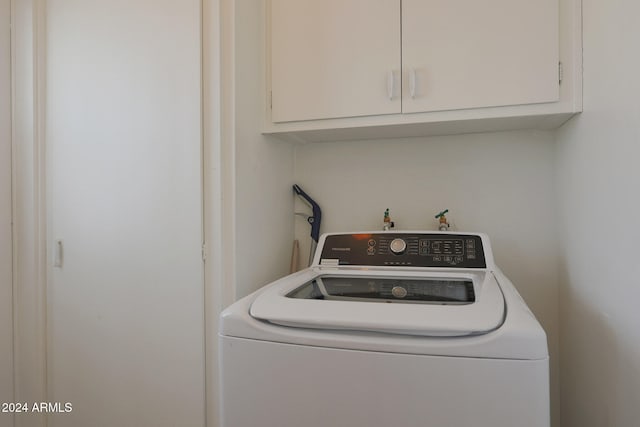 clothes washing area with cabinets and washer / dryer