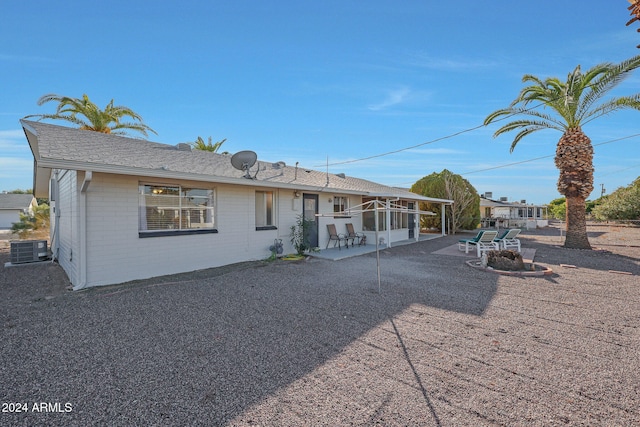 rear view of house with a sunroom, a patio area, and central AC