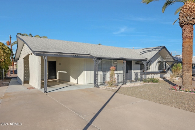 rear view of house with covered porch and a carport