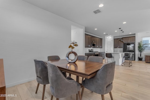 dining room with light wood-type flooring and recessed lighting