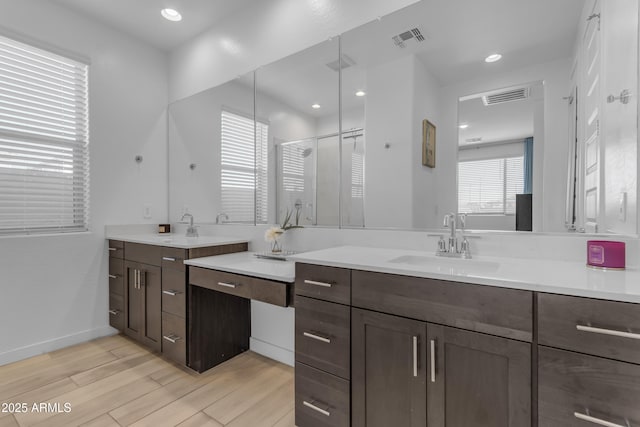 bathroom featuring a shower stall, wood finished floors, vanity, and recessed lighting