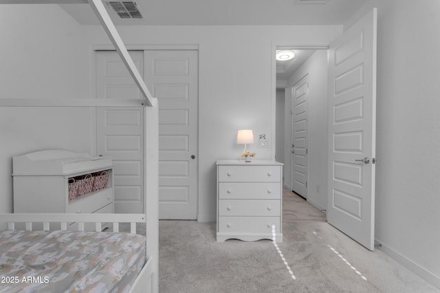 bedroom featuring light carpet, baseboards, and a closet