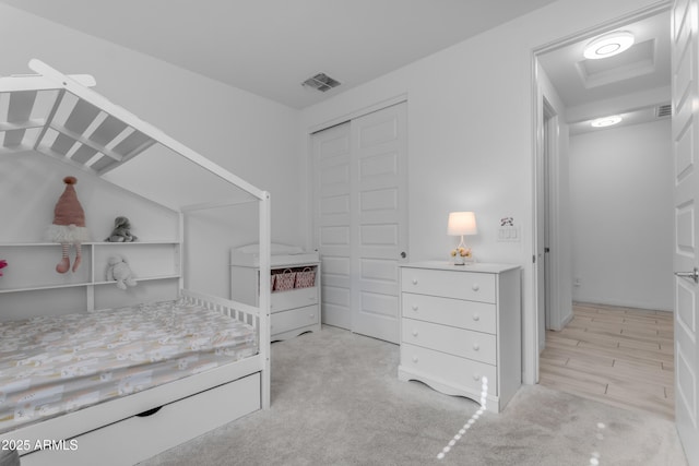 bedroom with a closet and light carpet