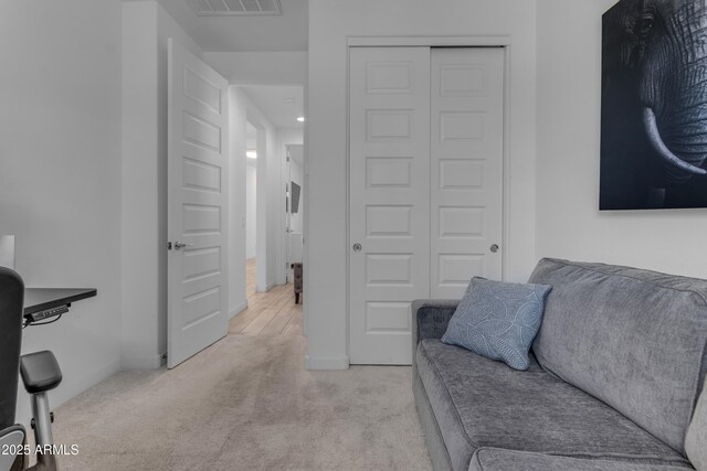 living area featuring light colored carpet and baseboards