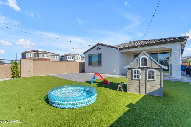 back of house featuring a patio area, stucco siding, and a tile roof
