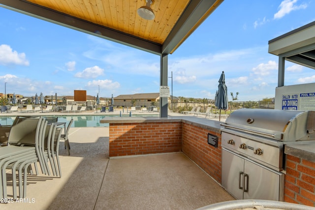 view of patio / terrace featuring an outdoor kitchen and a community pool