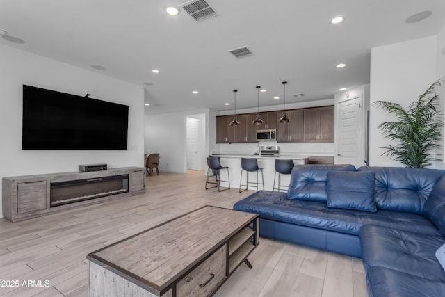 living room with light wood-style flooring and recessed lighting