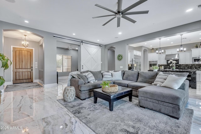 living room featuring a barn door and ceiling fan