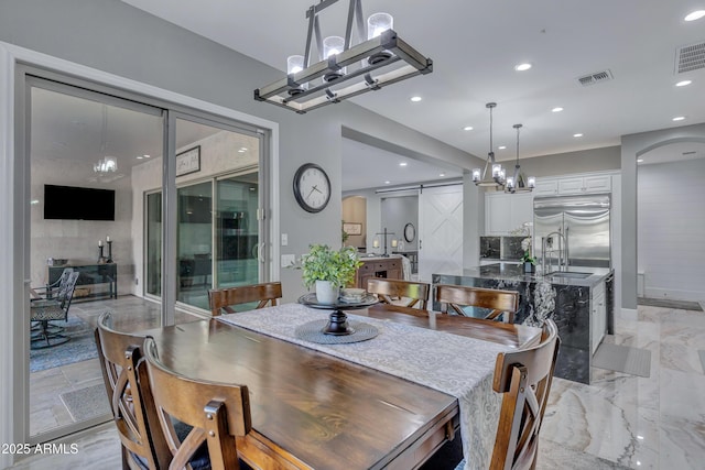 dining area with a barn door and sink