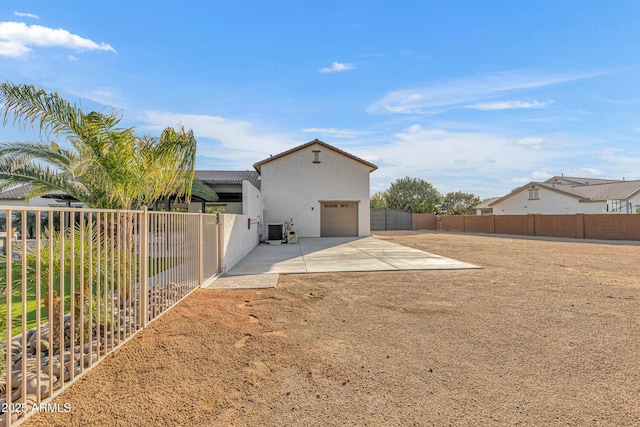 back of house featuring a patio, a garage, and central AC unit