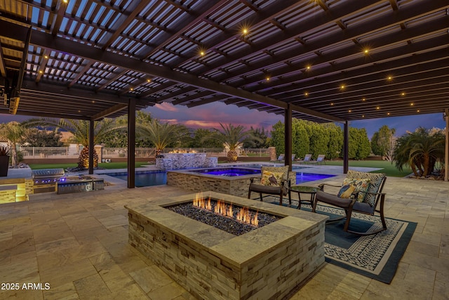 patio terrace at dusk featuring a pergola, a pool with hot tub, and an outdoor fire pit