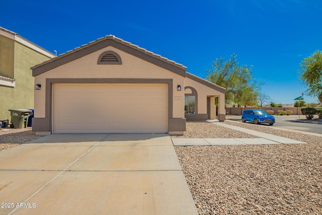 view of front of house with driveway, stucco siding, and an attached garage