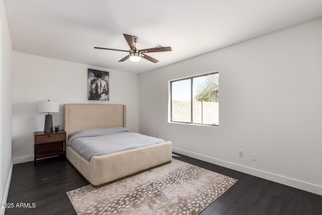 bedroom with a ceiling fan, dark wood-style flooring, and baseboards