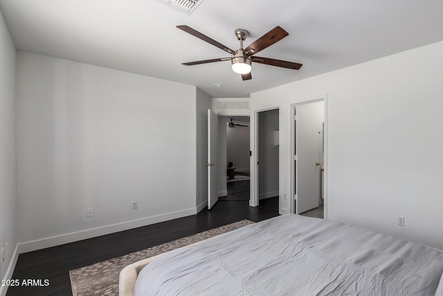 bedroom featuring a ceiling fan, visible vents, baseboards, and wood finished floors