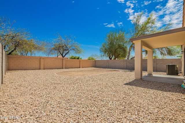 view of yard with a fenced backyard, a patio, and central AC