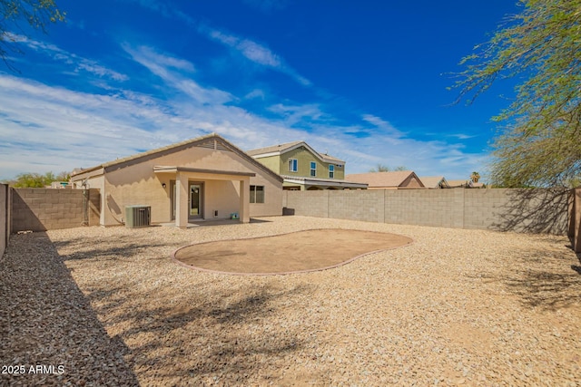 back of property featuring a patio, stucco siding, a fenced backyard, and central AC