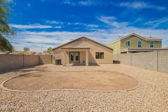 rear view of house featuring a fenced backyard, stucco siding, a patio, and french doors
