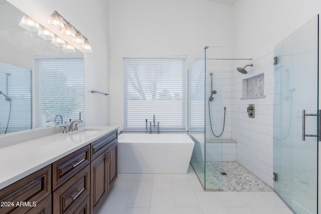 bathroom featuring a wealth of natural light, tile patterned floors, vanity, and shower with separate bathtub