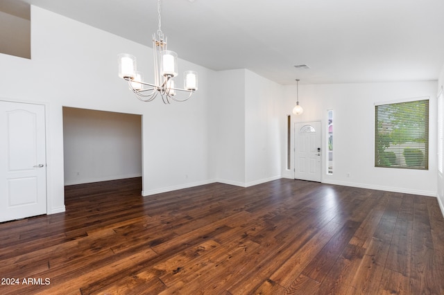 interior space featuring lofted ceiling, dark hardwood / wood-style flooring, and a notable chandelier