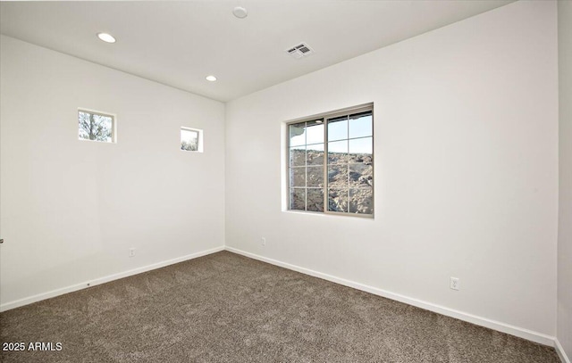 empty room with recessed lighting, baseboards, dark carpet, and visible vents