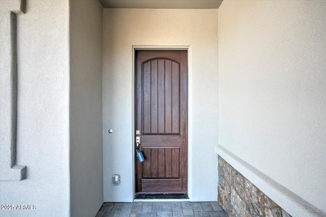 entrance to property with stucco siding