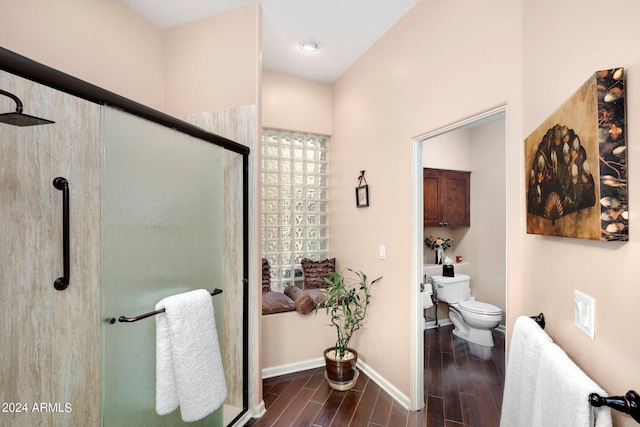 bathroom with toilet, a shower stall, baseboards, and wood finish floors