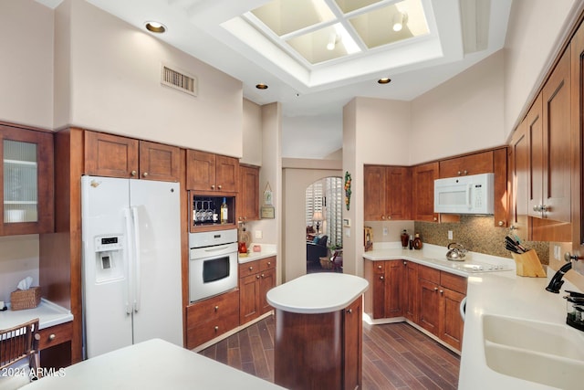 kitchen featuring white appliances, visible vents, and brown cabinets