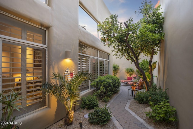 exterior entry at dusk featuring a patio and stucco siding