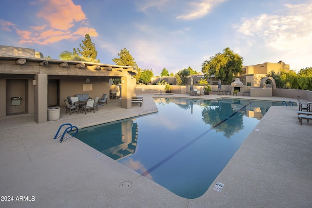 community pool featuring a patio and a fireplace