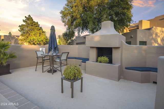 view of patio with outdoor dining area and exterior fireplace