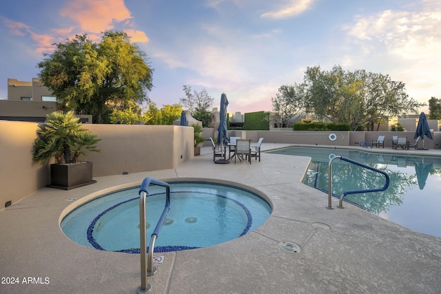 view of pool with fence, a hot tub, and a patio