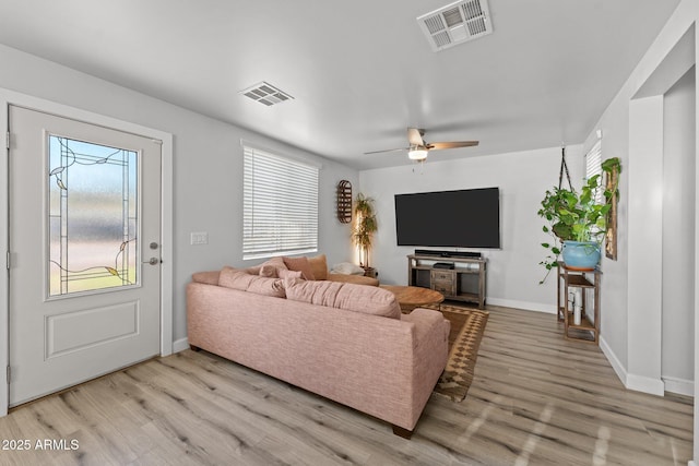 21647 W Laura St, Wittmann, AZ 85361 - living area with light wood-style floors, healthy amount of natural light, and a ceiling fan
